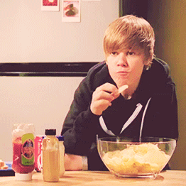 Justin Bieber in kitchen eating chips from bowl