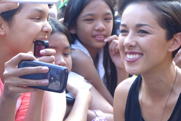 Kina Grannis taking photos with fans on the red carpet