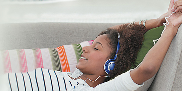 Girl relaxing on couch with headphones music