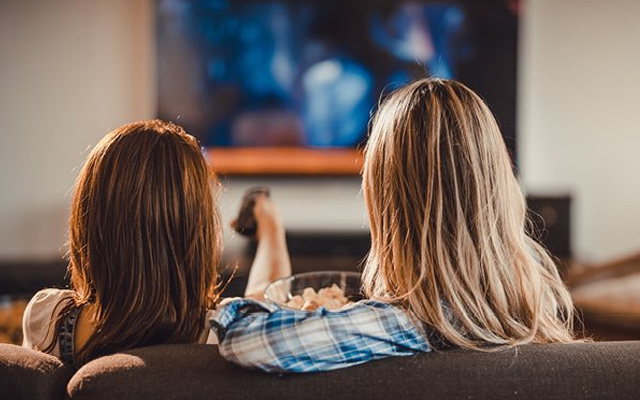 women friends watching tv movie night
