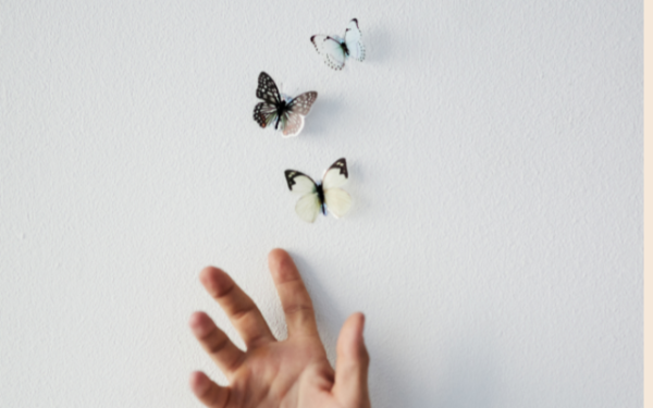 open hand releasing three butterflies